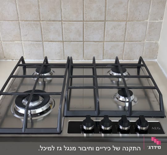 כיריים גז עם ארבעה מבערים וכפתורי שליטה